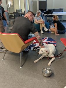man sitting in chair petting dog on the floor